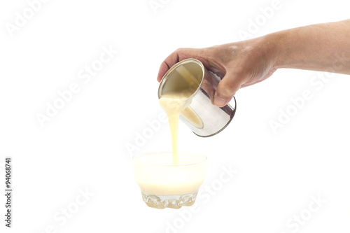 Man hand pouring condensed milk into a bowl