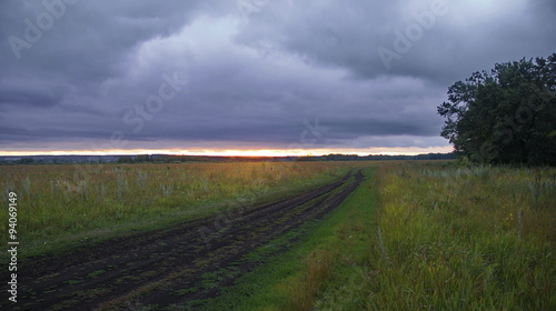  country road in field. Picture of a country road on a cloudy day in the evening at sunset
