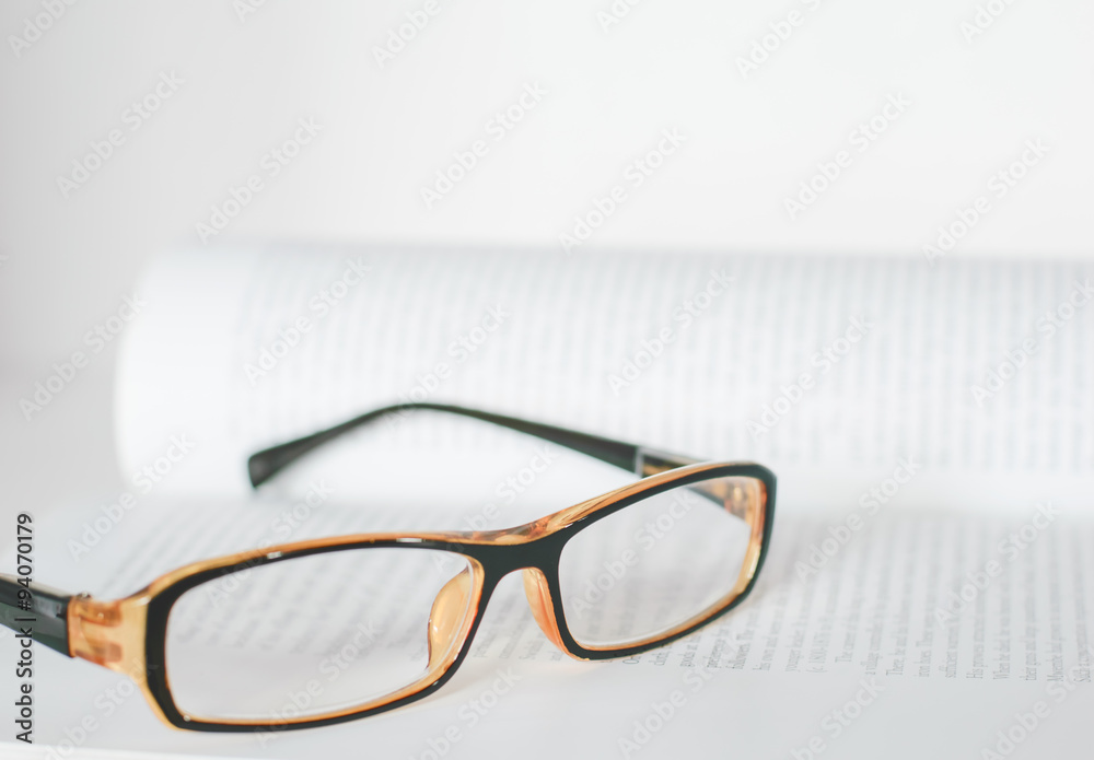 Eyeglass on book Eyeglass on book