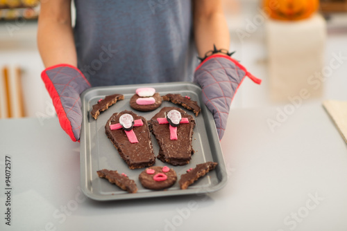 Closeup on tray with Halloween cookies in hands of housewife