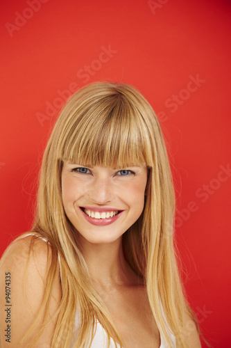 Happy young woman against red background