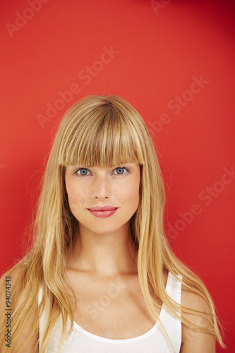 Blue eyed blond woman on red background