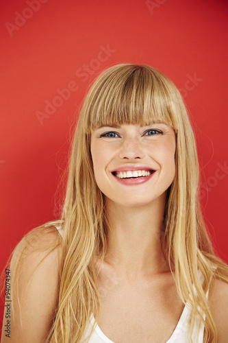 Happy young blond lady smiling at camera
