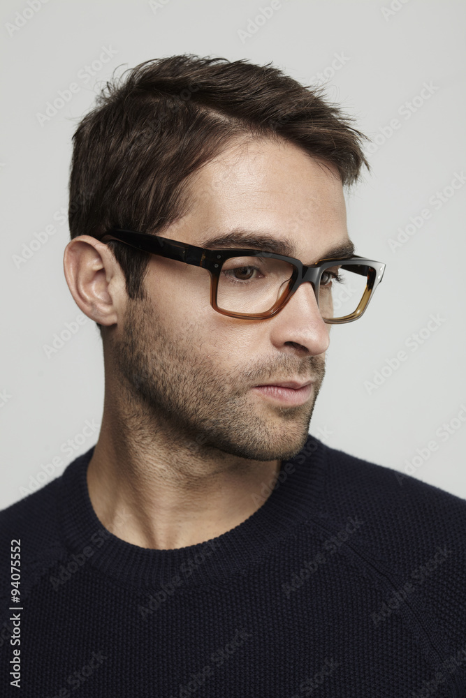 Thoughtful man in glasses looking away in studio Thoughtful man in glasses looking away in studio