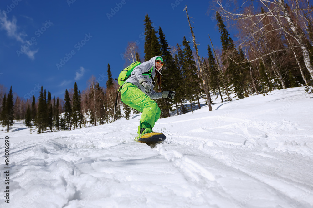 Snowboarder doing a toe side carve with deep blue sky in backgro