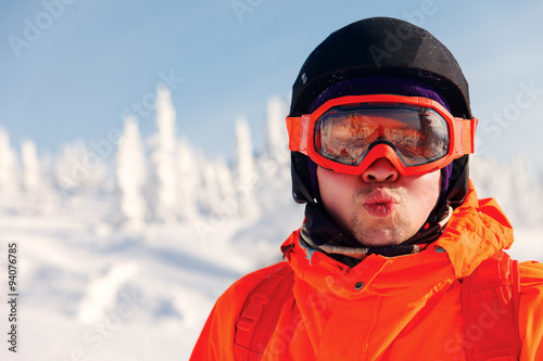 Portrait of a snowboarder in the winter resort in sunglasses mask at ski resort in mountains © aleksey ipatov