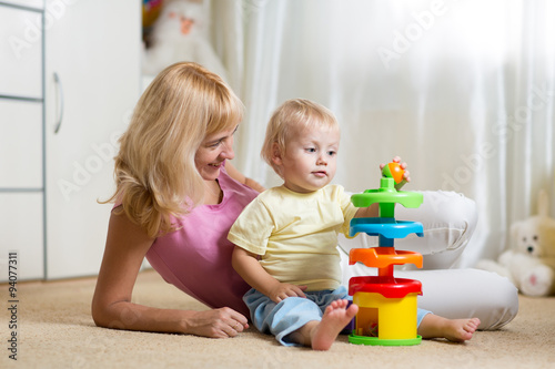 mother and her child playing with colorful logical toy