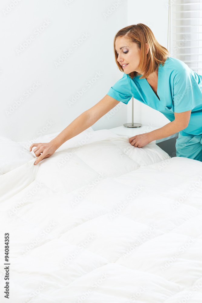 Zimmermädchen macht Bett im Seniorenheim