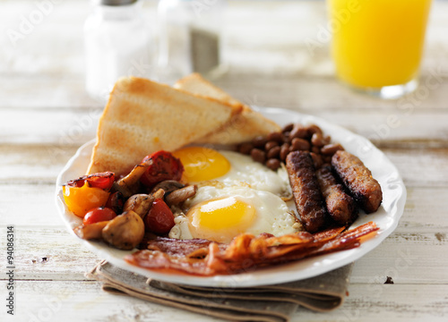 traditional english breakfast on rustic table with orange juice