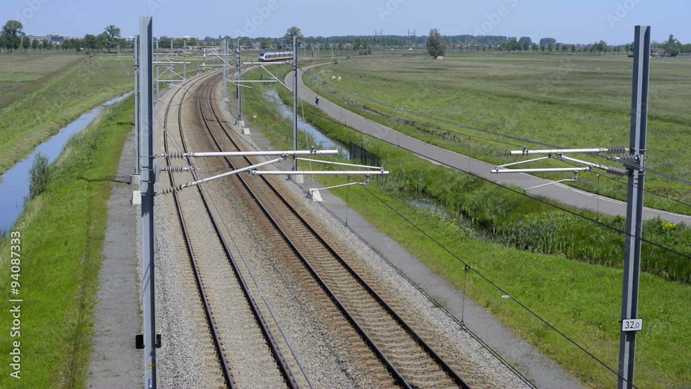 White and blue passenger train passing by at high speed.