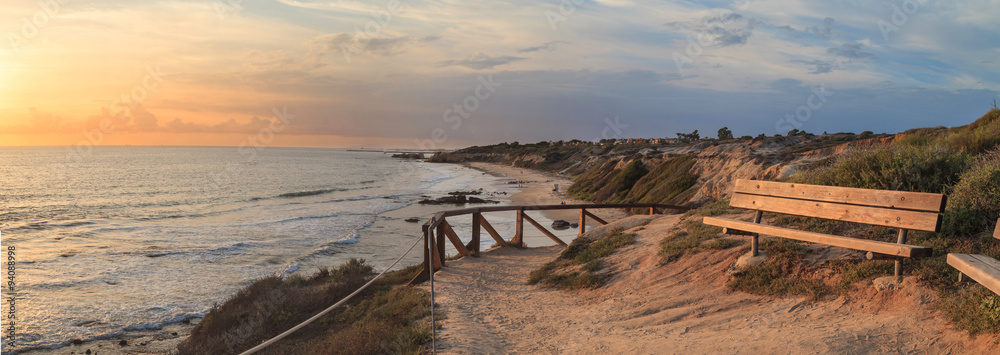 Naklejka premium Ławka wzdłuż punktu widokowego z widokiem na zachód słońca na Crystal Cove Beach, Newport Beach i Laguna Beach w południowej Kalifornii