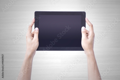 Fotografi Man hand holding tablet tablet screen showing up overhead person wood background