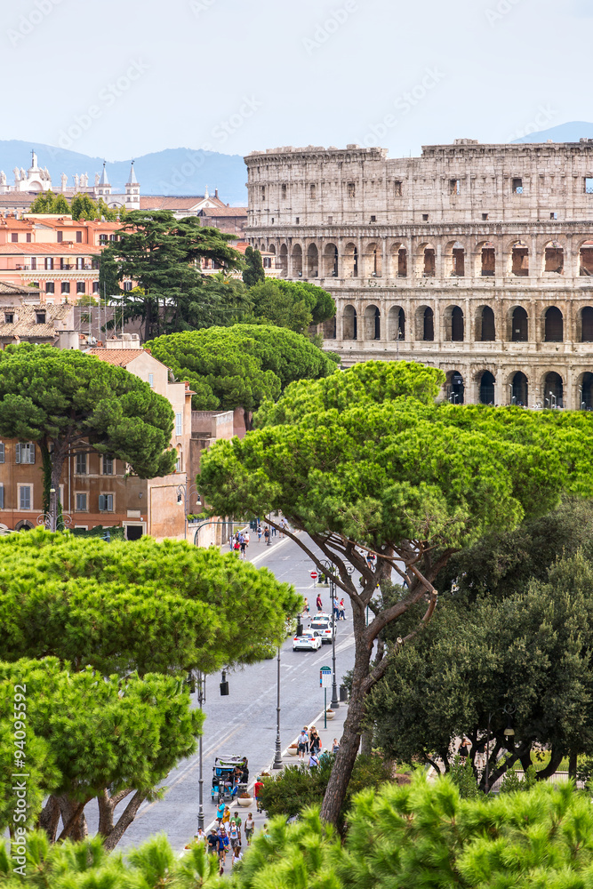 Exterior view of the Colosseum in Rome with green trees around.