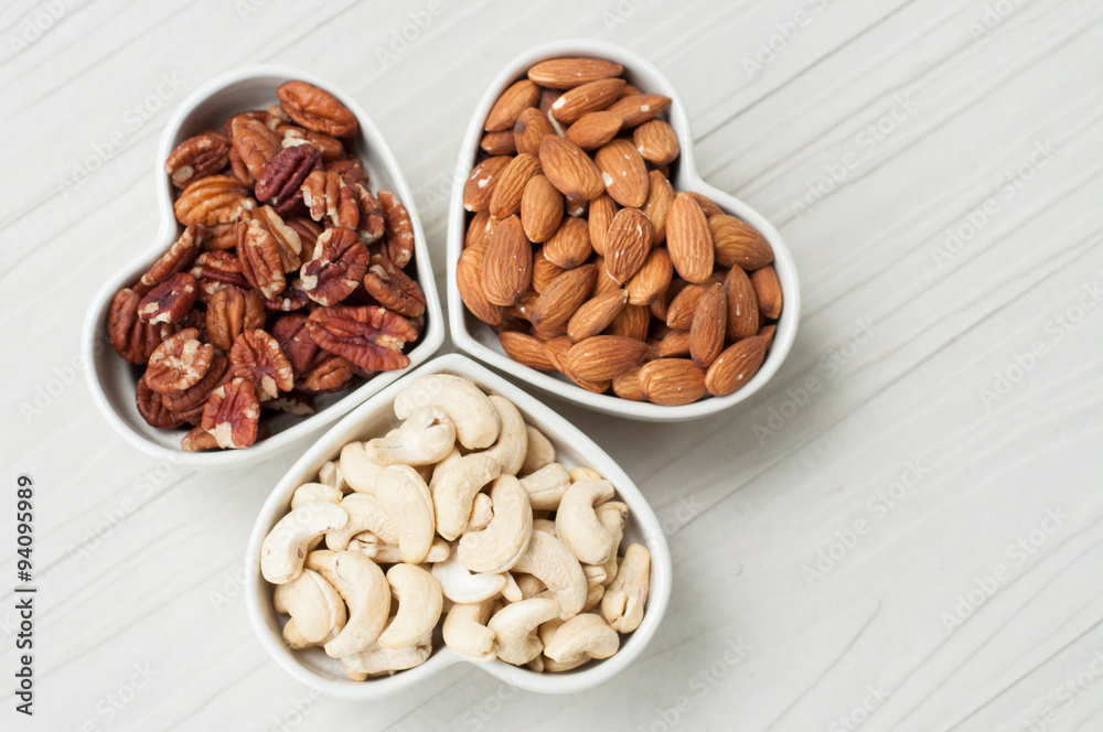 Assorted nuts in bowl on wooden table Assorted nuts in bowl on wooden table
