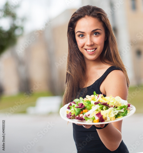 portrait of a young woman holding a fresh salad