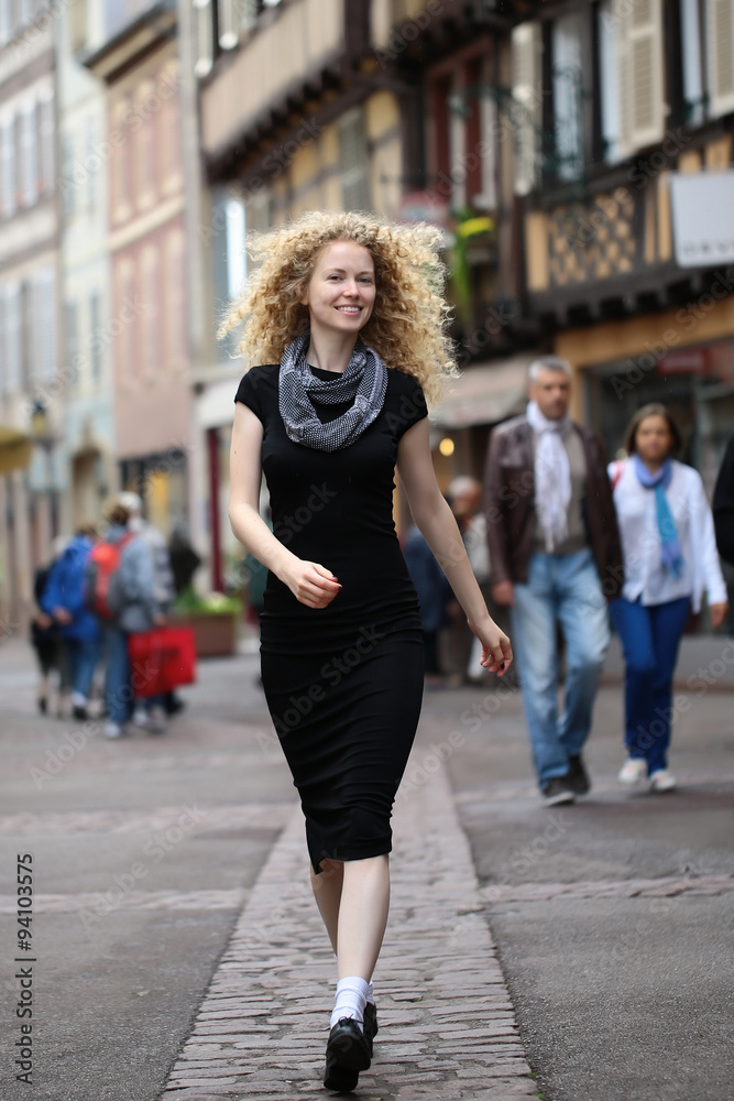Blond lady walking along street