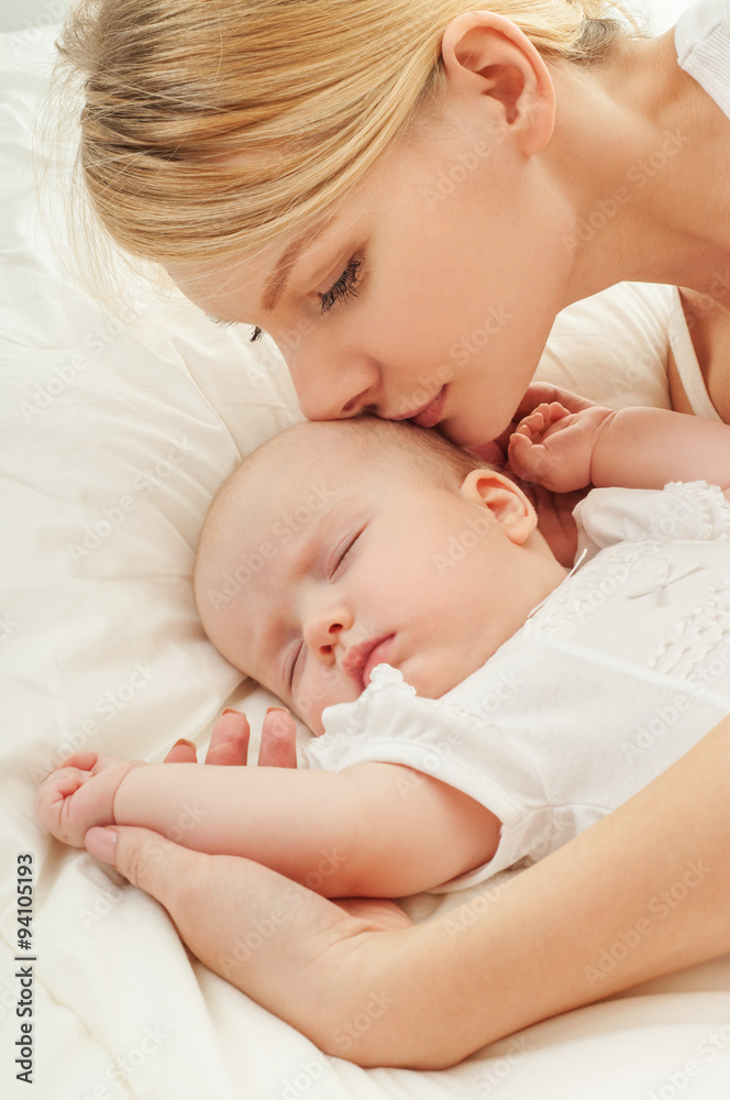 Young mother and her baby, sleeping in bed. Mother and baby. Hap Young mother and her baby, sleeping in bed. Mother and baby. Hap