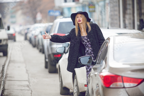 Photography fashionable young woman posing outside in a city street