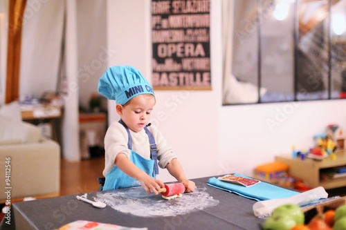Tableau sur toile Un jeune enfant joue à cuisiner des gâteaux
