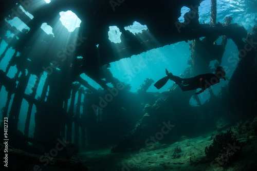 Free Diver Swimming Through Shipwreck