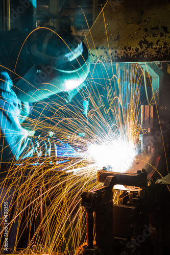 sparks while welder uses torch to welding