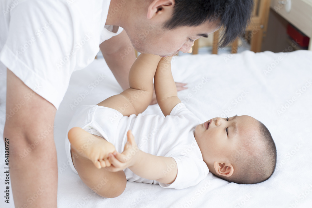Chinese father and son playing in bed