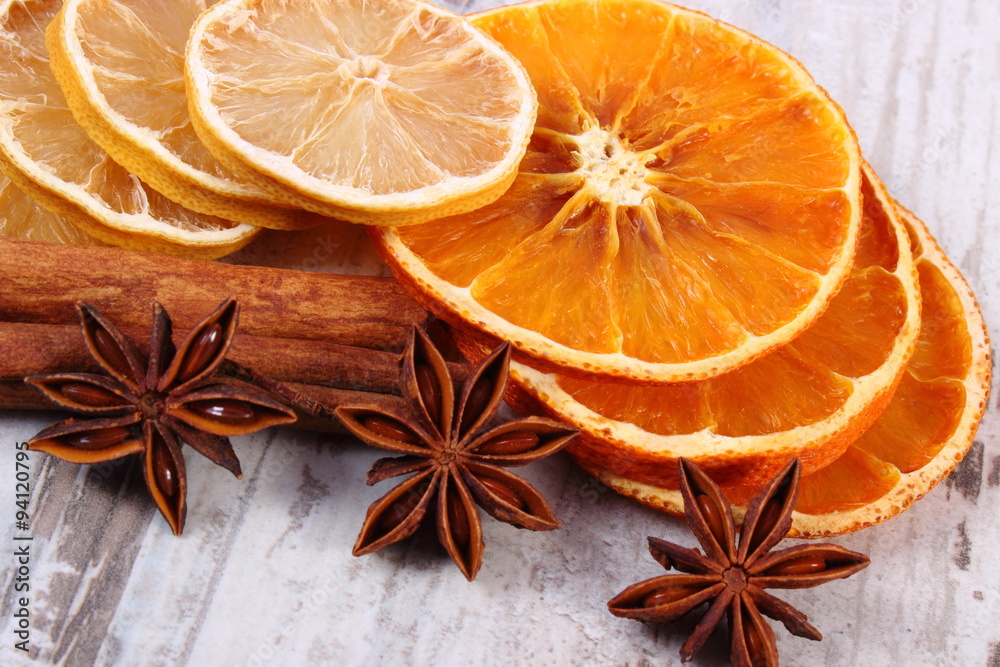 Slices of dried lemon, orange and spices on old wooden background Slices of dried lemon, orange and spices on old wooden background