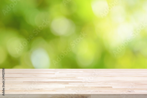 Wood table top on bokeh abstract green background