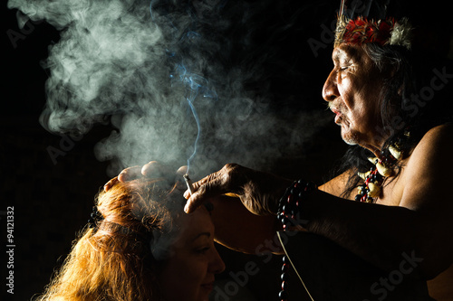 A Mayan shaman performs an ayahuasca ceremony in the Amazon jungle of Ecuador, using plant medicine to heal and guide people in a spiritual ritual. photo
