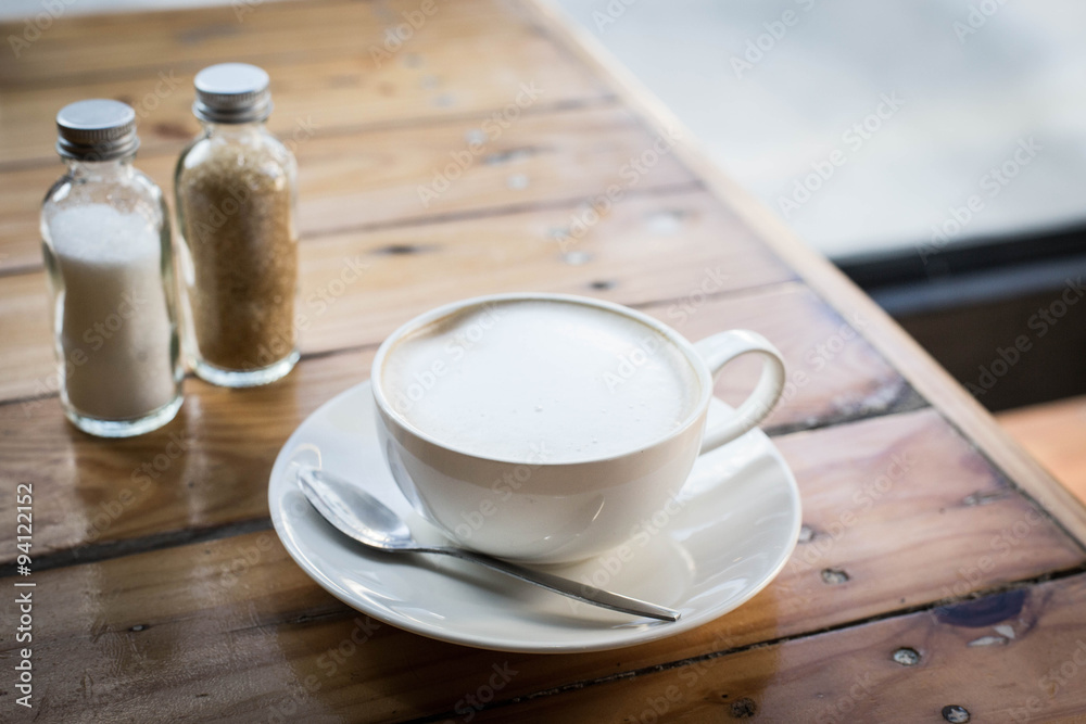 Hot art Latte Coffee in a cup on wooden table and Coffee shop bl Hot art Latte Coffee in a cup on wooden table and Coffee shop bl