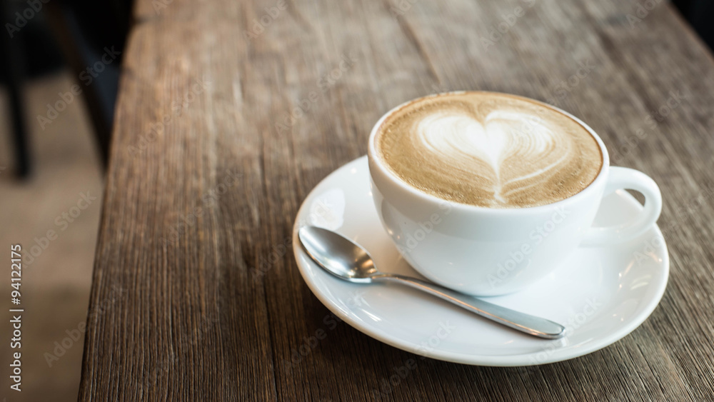 Hot art Latte Coffee in a cup on wooden table and Coffee shop bl Hot art Latte Coffee in a cup on wooden table and Coffee shop bl