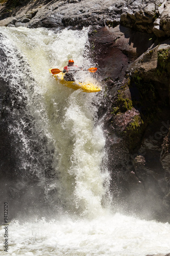 A thrilling image of a kayak jumping over rapids at Sangay waterfall in Ecuador, surrounded by white water and filled with extreme action and fun. © Ammit