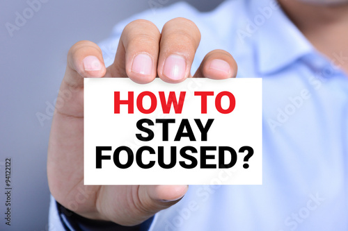 HOW TO STAY FOCUSED? message on the card shown by a man