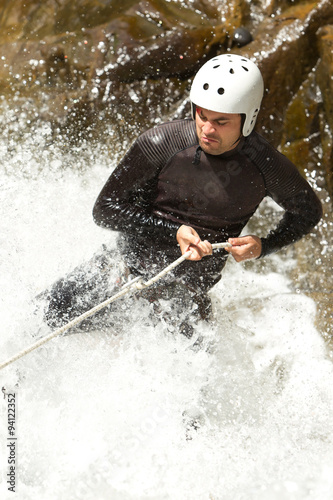 Fototapeta Naklejka Na Ścianę i Meble -  Watch as an experienced adult man skillfully descends a breathtaking Ecuadorian waterfall,showcasing perfect form and technique.