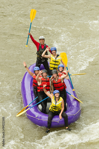 A family team rows their raft through thrilling whitewater rapids, laughing and having fun while enjoying the adrenaline rush of white water rafting.