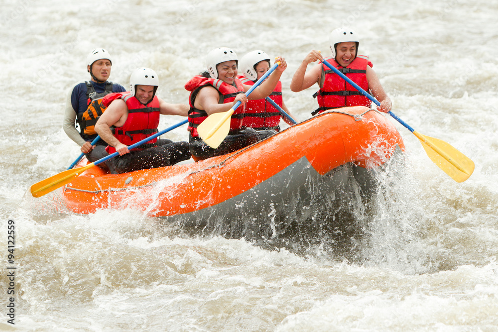A team of adventurers paddle through the white waters of an extreme river on a thrilling rafting expedition, showcasing their outdoor teamwork.