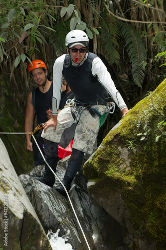 Experienced canyoning expert providing expert guidance to tourists for an exhilarating waterfall descent adventure. photo