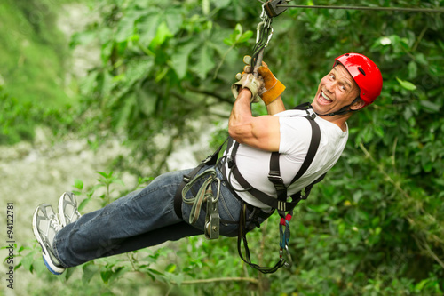 A man flying through the trees on a zipline, feeling the rush of adrenaline on an adventurous tour.