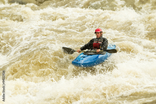 A thrilling image of a white-water kayak navigating through extreme rapids, splashing water everywhere as the adrenaline-fueled sport of rafting is enjoyed. © Ammit