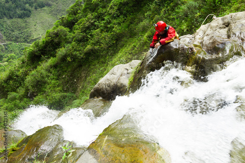 Experienced canyoning instructor unveiling an exciting new route at Chamana Waterfall,Banos de Agua Santa,Ecuador a top tourist spot in the country.