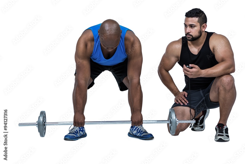 Man lifting barbell with trainer Man lifting barbell with trainer