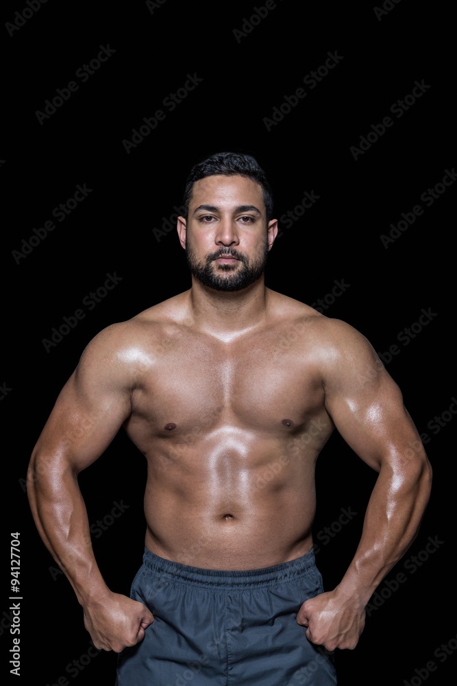 Fototapeta premium Portrait of a bodybuilder man flexing muscles