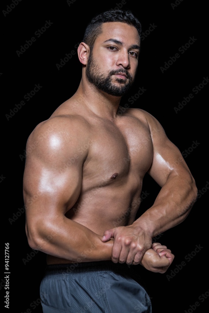 Fototapeta premium Portrait of a bodybuilder man flexing muscles