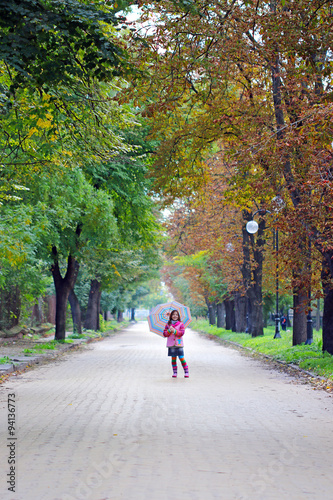 little girl with umbrella on street autumn season © goce risteski