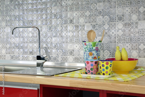 Modern sink with fancy cup and utensil in kitchen room