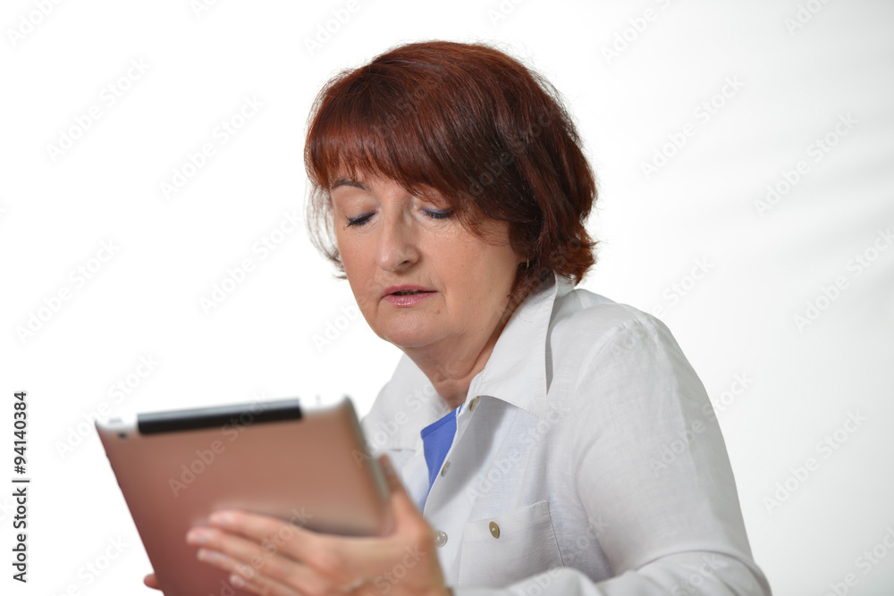 elegant senior woman concentrated working on her tablet pc elegant senior woman concentrated working on her tablet pc