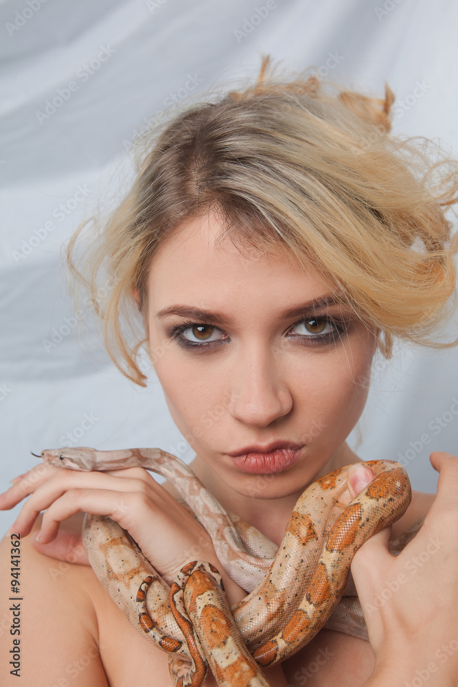 Naklejka premium Beautiful girl and the snake Boa constrictors, which wraps
