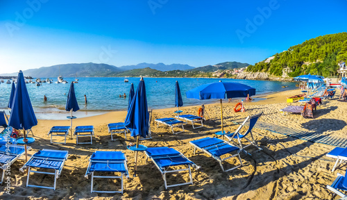 Vacation beach scenery with beachchairs and sunshades on a sunny day photo