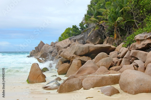 Beach with rocks and palm trees on the island Praslin, Seychelles