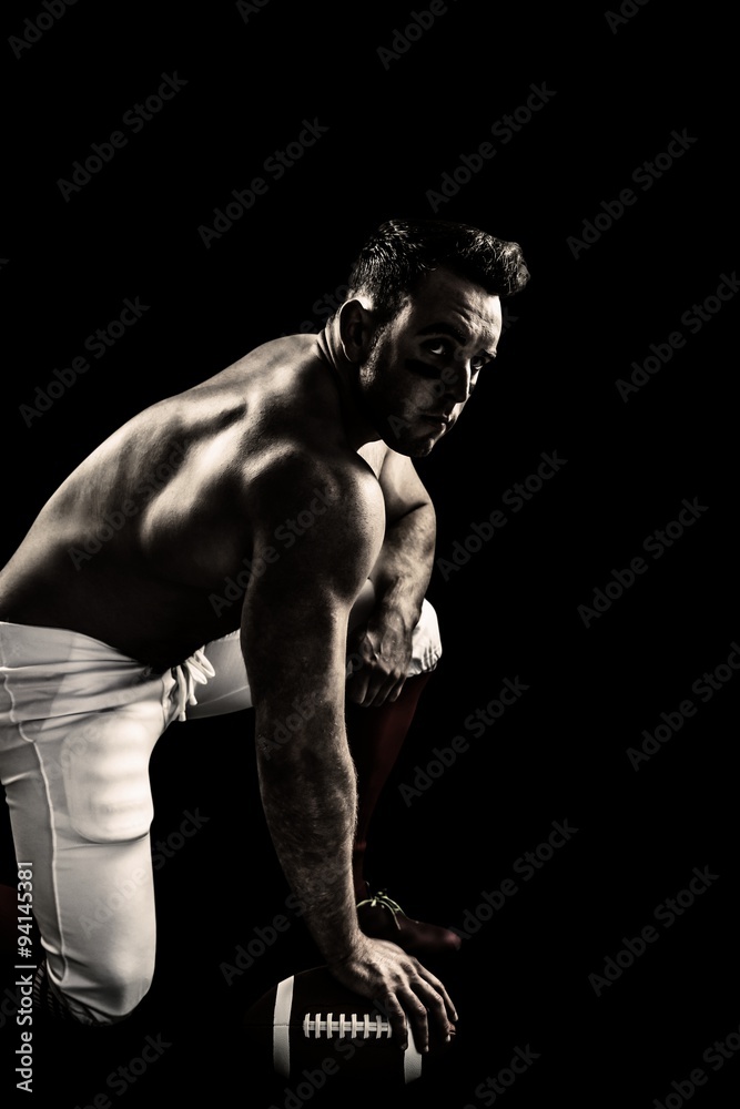 Composite image of shirtless american football player with ball Composite image of shirtless american football player with ball